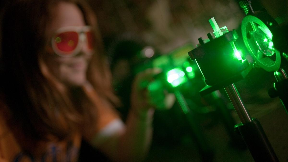 Student with protective glass in photonics lab